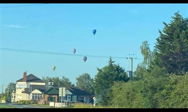 Man die aan een heteluchtballon bungelt, sterft nadat hij op een rijdende auto beneden is gevallen